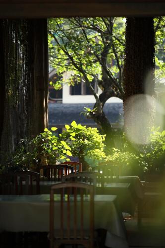 a group of tables and chairs in a garden at VC@Suanpaak Boutique Hotel & Service Apartment in Chiang Mai
