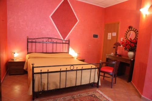 ein Schlafzimmer mit einem Bett und einer roten Wand in der Unterkunft B&B Rinascente in Paola