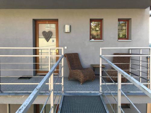 a front porch of a house with a door and a chair at Apartmán Provence in Luhačovice