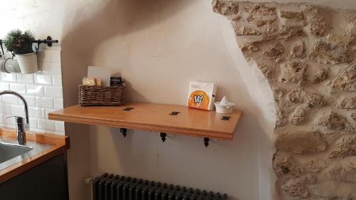 eine Küche mit einem Holzregal an der Wand in der Unterkunft LA CASA DI ROSA in Rivisondoli