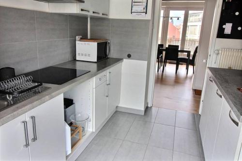 une cuisine avec des armoires blanches et un comptoir dans l'établissement 3 pièces en plein centre de Strasbourg, à Strasbourg