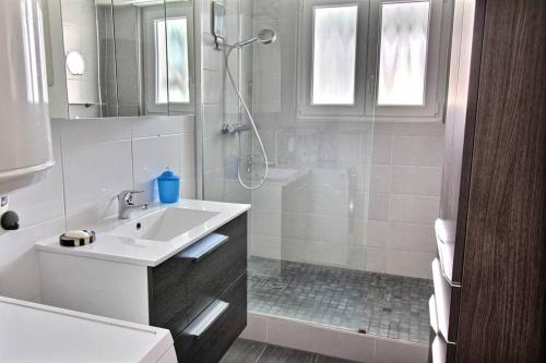 une salle de bain blanche avec un lavabo et une douche dans l'établissement 3 pièces en plein centre de Strasbourg, à Strasbourg