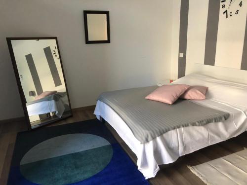 Dormitorio con cama con espejo y alfombra en Monolocale arredato con una camera, en Parma