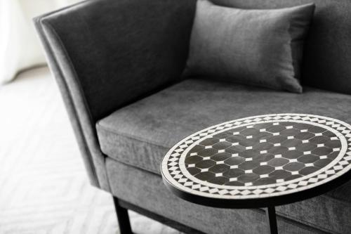 a black and white photo of a chair with a table at Kimpton Hotel Fontenot by IHG in New Orleans