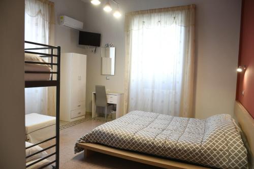 een slaapkamer met een bed, een bureau en een raam bij B&B Enjoy Ercolano in Ercolano