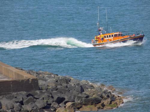 an orange boat in the water near a pier at Widows Row Cottage in Newcastle