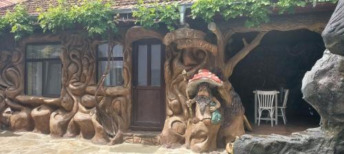a wooden house with a statue of a tree at Хаджи Марковата къща за гости гр.Дряново in Dryanovo