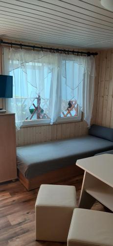 a small room with a bed and a window at Pokoje&Domki Andrzej Kaczor in Pobierowo