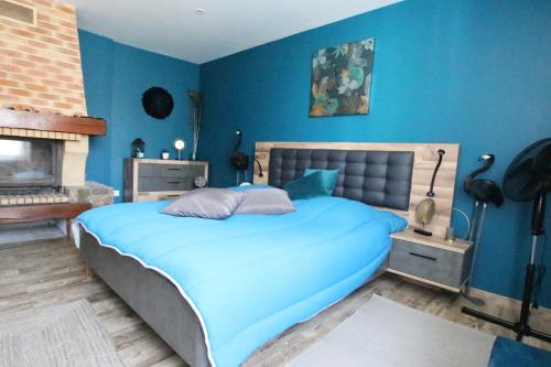 une chambre bleue avec un lit et une cheminée dans l'établissement Colmar City Center - Apartment Duplex MARIGNY - BookingAlsace, à Colmar