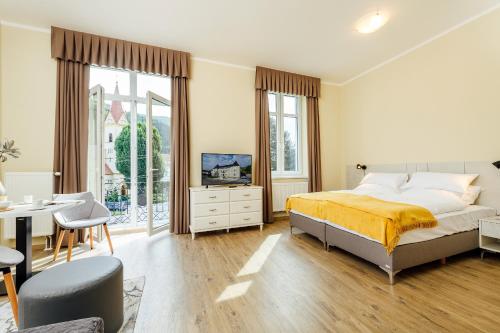 Schlafzimmer mit einem Bett, einem Schreibtisch und einem TV in der Unterkunft Apartmánový dom GRAND - Contactless Check In in Trenčianske Teplice