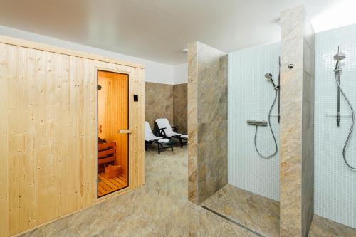 a bathroom with a shower and a walk in shower at Apartmánový dom GRAND - Contactless Check In in Trenčianske Teplice