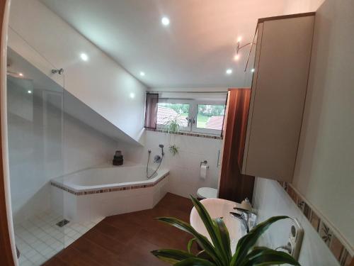 a bathroom with a bath tub and a sink at Haus Heidi in Freyung