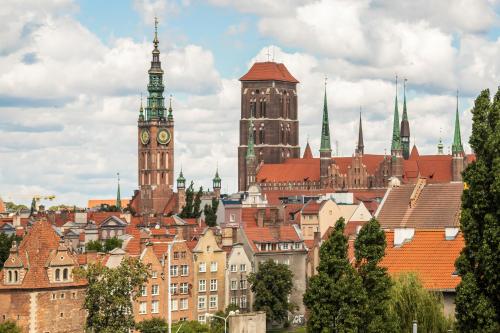 um horizonte da cidade com uma torre de relógio e edifícios em Apartments Jaglana near Old Town by Renters em Gdansk