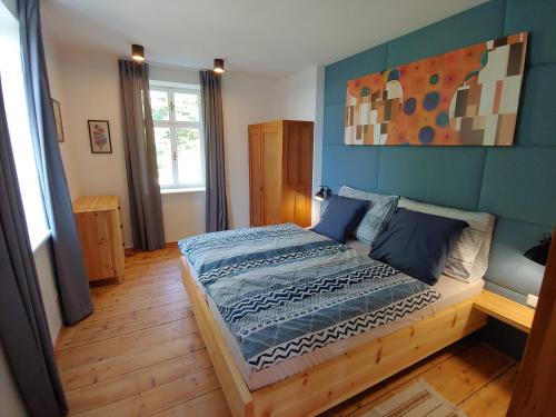 um quarto com uma cama com um quadro na parede em Ferienhaus zur Opernsängerin em Hartberg