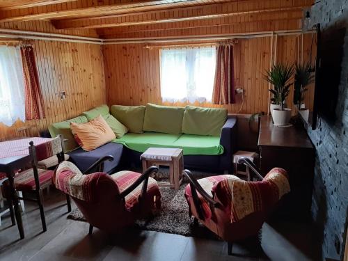sala de estar con sofá verde y sillas en Fleurs de Mýto, en Mýto pod Ďumbierom