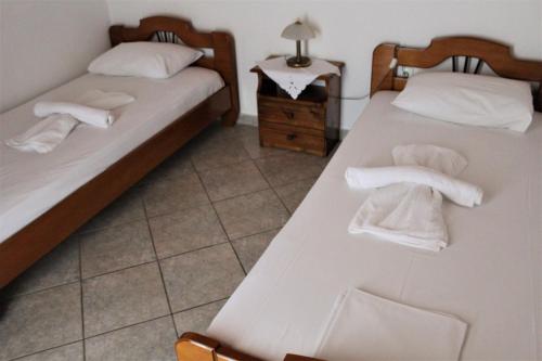 - 2 lits dans une chambre avec des serviettes dans l'établissement Koula's Place, à Elafonisos