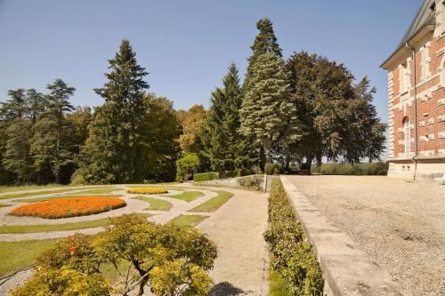 un jardin avec un chemin en face d'un bâtiment dans l'établissement Chateau de Joyeux - Chambres d'Hotes, à Joyeux