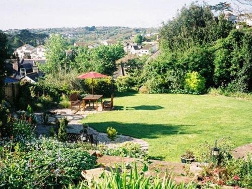 a garden with a table and an umbrella at amber house hotel in Paignton