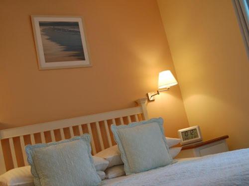 um quarto com uma cama com almofadas azuis e um candeeiro em amber house hotel em Paignton