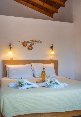 a bed with two towels and a bottle and two glasses at Cavo Gallo in Finikounta