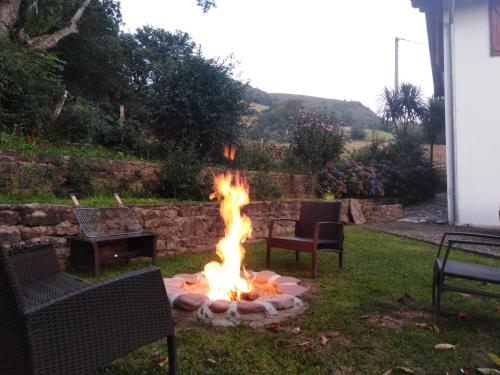 a fire pit in a yard with two chairs at GITE IBARLA BORDA in Bidarray