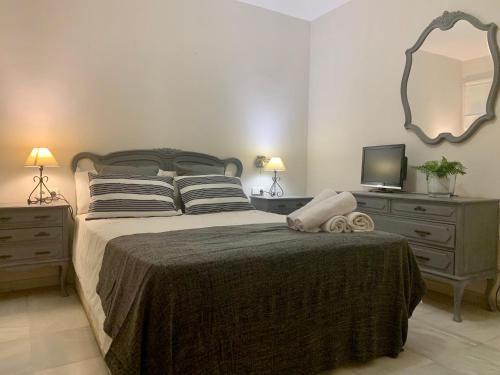 1 dormitorio con cama, tocador y espejo en Villa Ana María, en Torremolinos