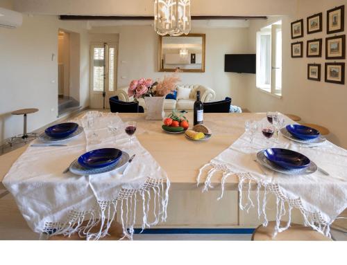 a table with blue plates and wine glasses on it at Casa Collodi Castello in Collodi