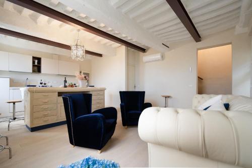 a living room with a white couch and chairs at Casa Collodi Castello in Collodi