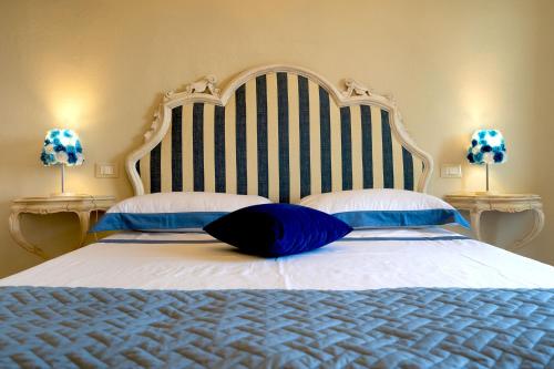 a large bed with a blue pillow on it at Casa Collodi Castello in Collodi
