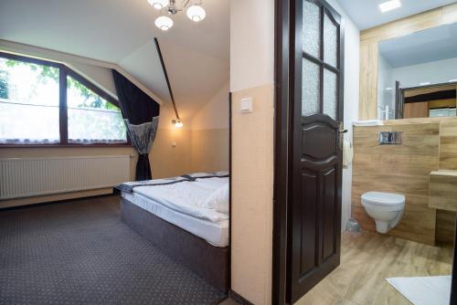 ein Schlafzimmer mit einem Bett, einem WC und einem Fenster in der Unterkunft Sangos Ośrodek Sportowo-Szkoleniowy in Górki Wielkie