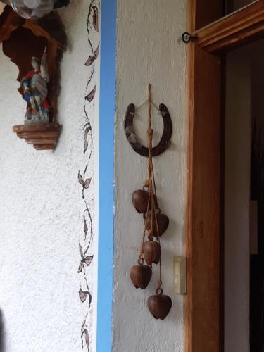 a wall with a bunch of bells hanging on it at Bed & Breakfast Dolomiti Bey Haus Pinter in Assling