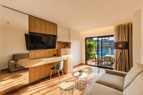 a living room with a couch and a flat screen tv at Mon Port Hotel & Spa in Port d’Andratx