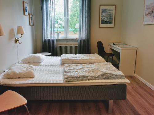 Falköpings Vandrarhem/Hostel في فالشوبنغ: غرفة نوم بسرير ومكتب ونافذة