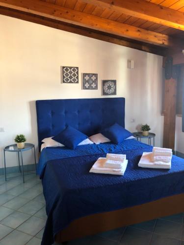 a bedroom with a blue bed with two plates on it at B&B Scala dei Turchi in Realmonte
