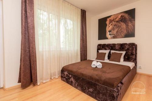 a bedroom with a bed with a lion picture on the wall at Palanga 777 - poilsio namai prie Birutės parko ir jūros in Palanga