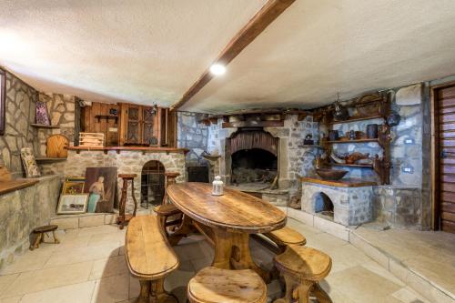 a kitchen with a wooden table and a stone fireplace at Rona Apartment & Rooms Mea Vista in Buzet