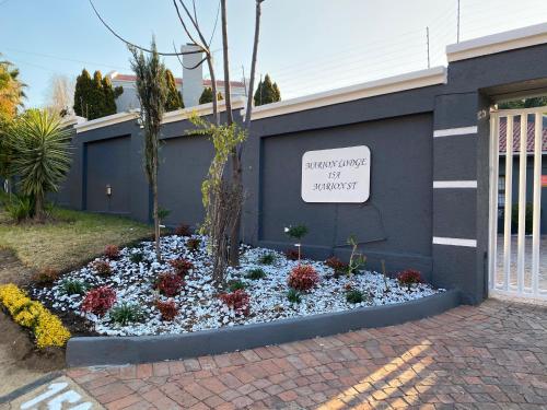 a garden of flowers in front of a building at Marion Lodge in Johannesburg