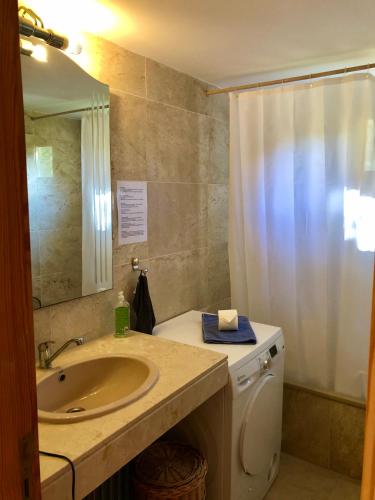 a bathroom with a sink and a shower curtain at Hartmut Friedrich Apartment Port de Soller in Port de Soller