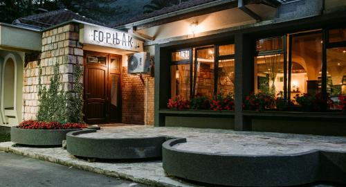 a store front of a building with benches in front at Restoran sa prenoćištem Gornjak in Krepoljin