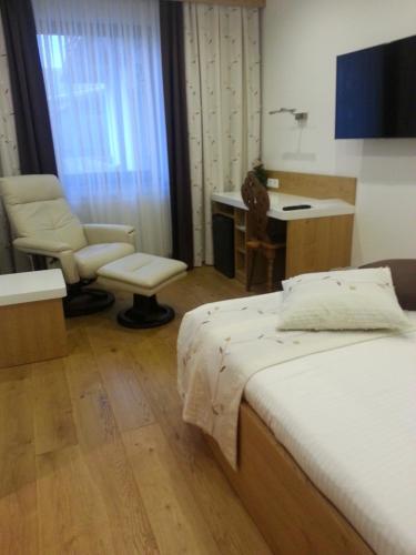 a bedroom with a bed and a desk and a chair at Penzion Tavcar in Ljubljana