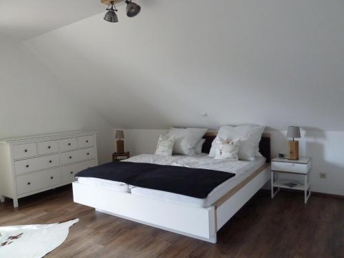 a bedroom with a white bed and a white dresser at Schinderhanneshof in Weitersborn
