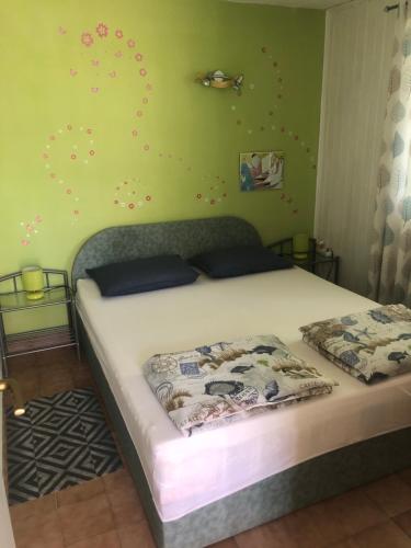 a bedroom with a bed and a green wall at Apartments Tomović in Korčula