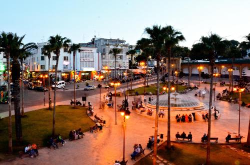 a group of people walking around a park at night at Hotel Mauritania in Tangier