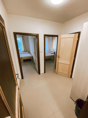 a hallway with two doors and a room with a bed at Chaty a Apartmány Hracholusky Kemp Kosatka in Pňovany