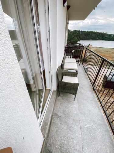 a balcony with a row of chairs on a building at Chaty a Apartmány Hracholusky Kemp Kosatka in Pňovany