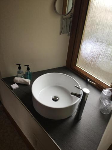 a white sink on a black counter in a bathroom at Bed and Breakfast at 4 in Thurso