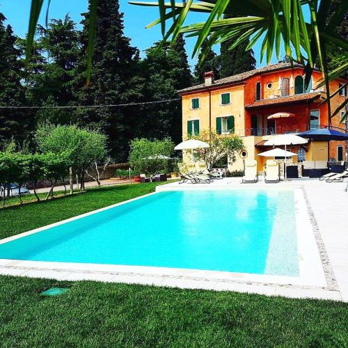 a large blue swimming pool in front of a house at Residenza Eden in Colà di Lazise