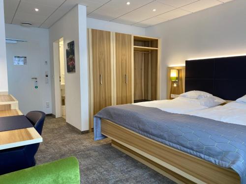 1 dormitorio con 1 cama grande y escritorio en Hotel Wieting, en Oldenburg