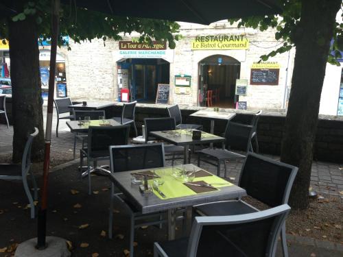 a restaurant with tables and chairs in front of a building at Hôtel La Tour D'Auvergne in Pont-lʼAbbé