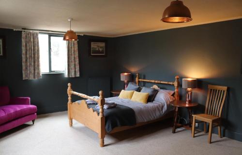 1 dormitorio con cama y sofá púrpura en Culm Valley Inn en Culmstock